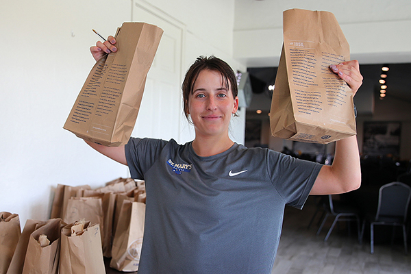 Volunteers helps pack lunches.